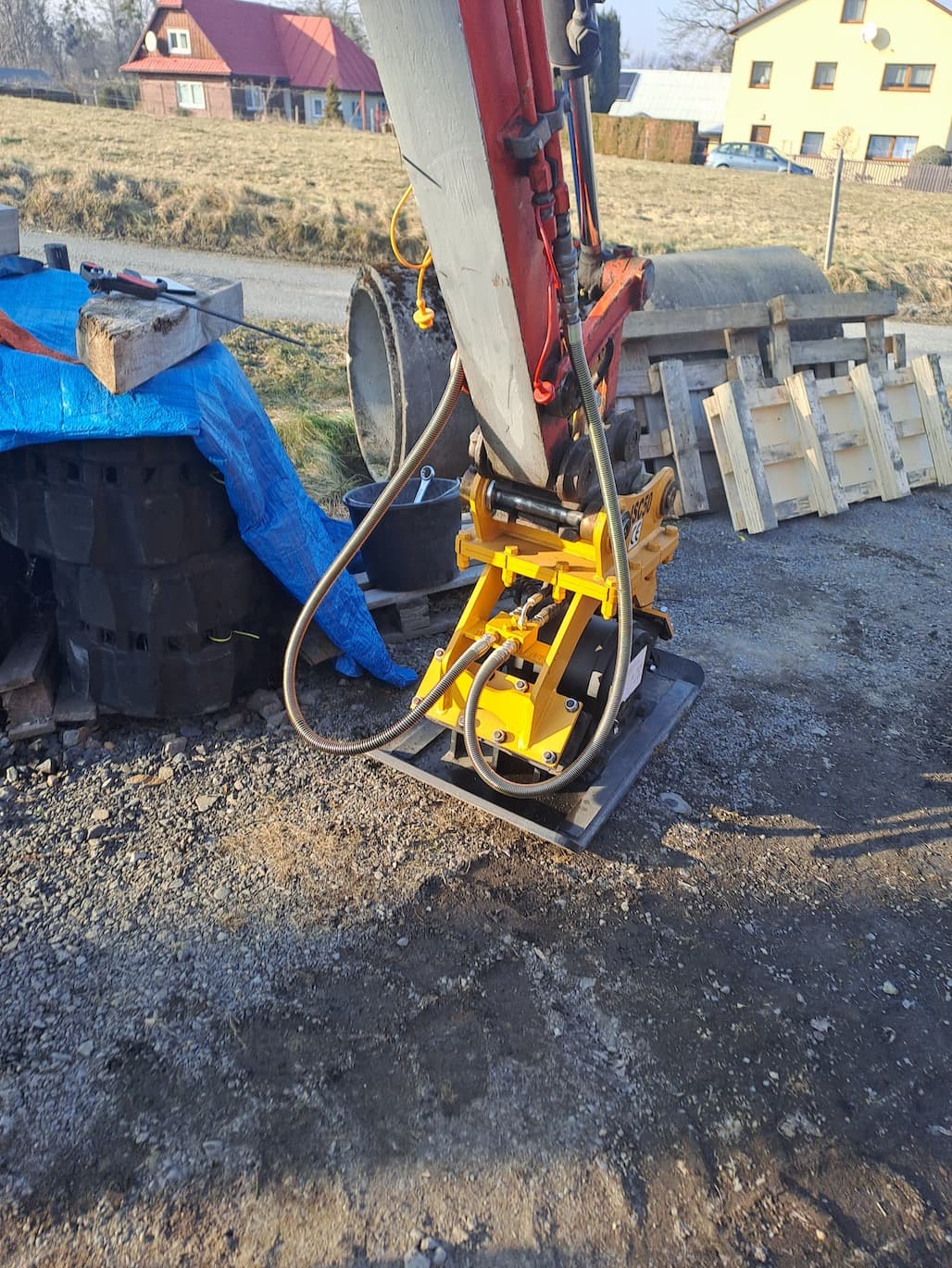 Hydraulická hutnící deska na rameni pásového bagru při hutnění štěrkového podkladu